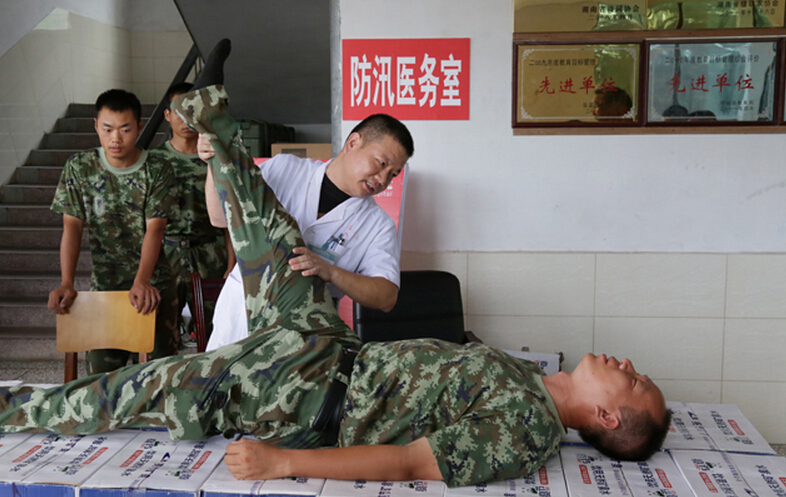 圖為醫(yī)療隊醫(yī)生在為8730部隊武警抗洪部隊官兵進行中醫(yī)正骨治療。
